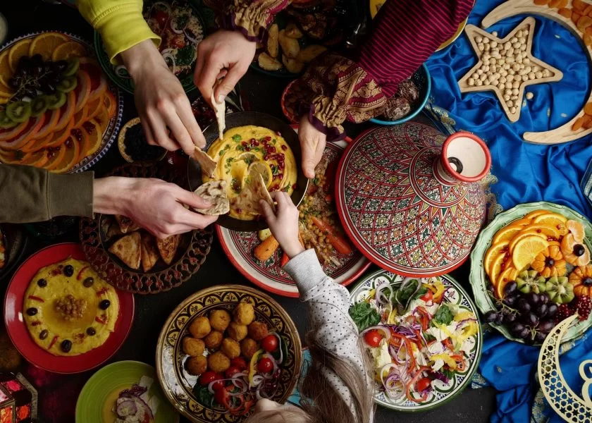 Families breaking their fast with traditional Saudi dishes during Ramadan.