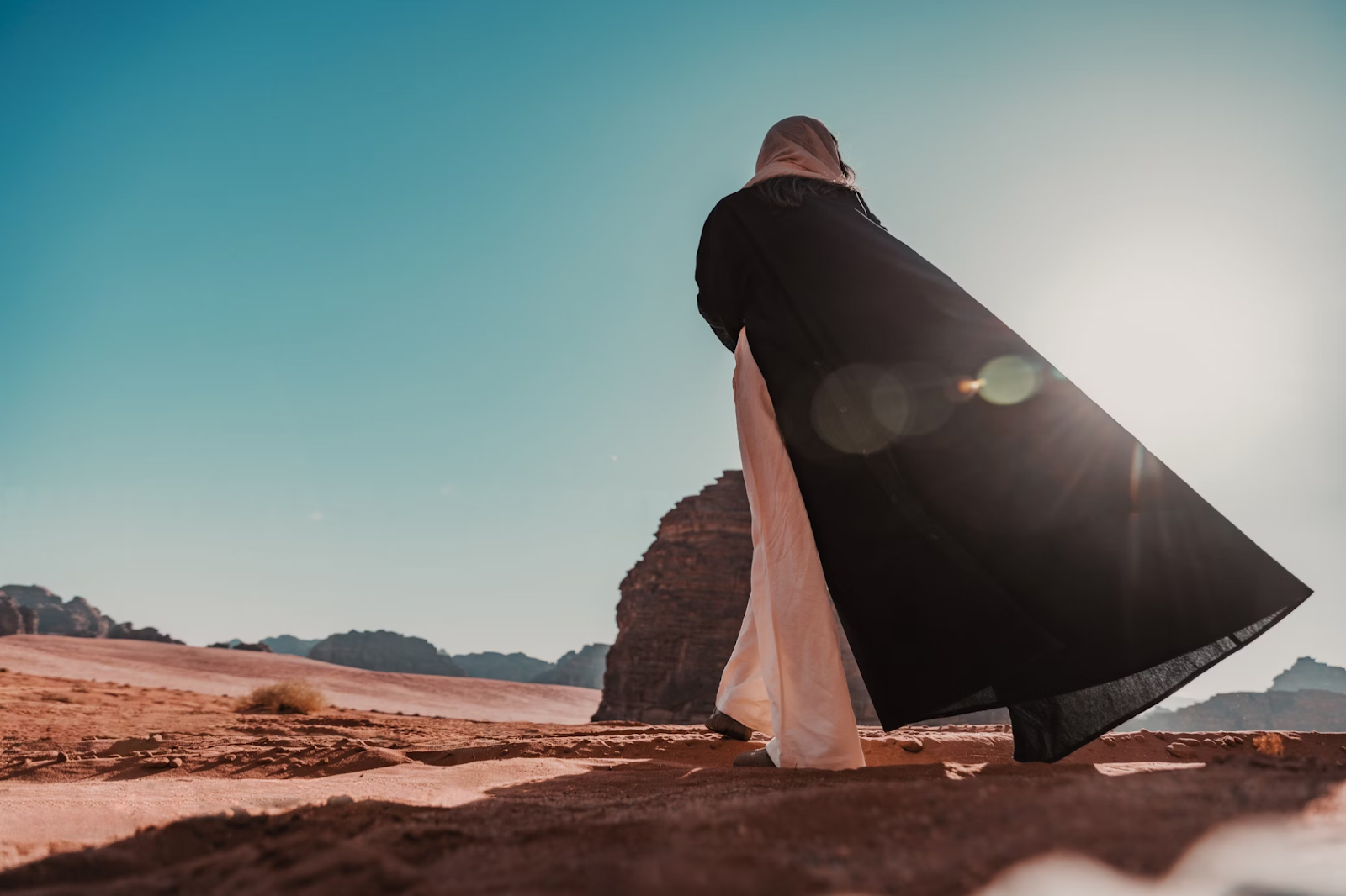 A solo female traveler wearing a full-length gown in AlUla, Saudi Arabia - (Credits Unsplash)