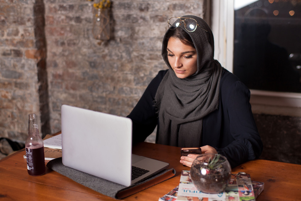 A Saudi woman entrepreneur working on her laptop - (Credits About Her)