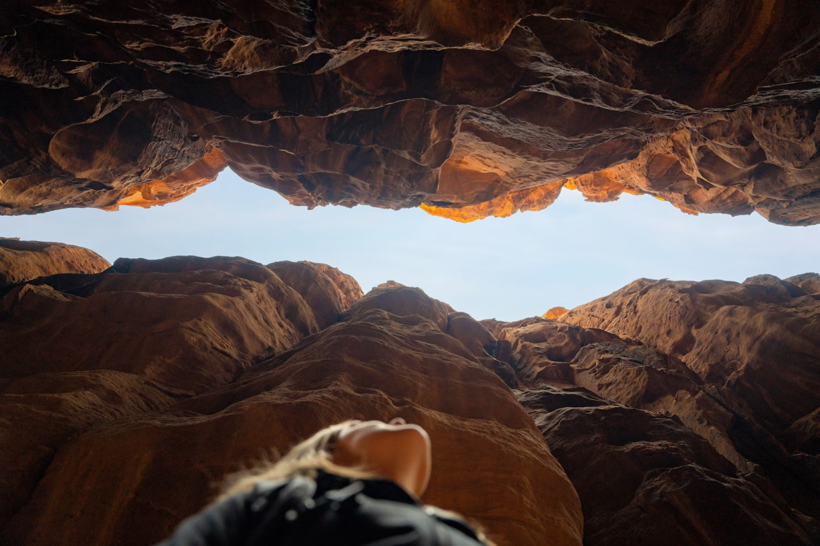 A woman standing between rock formations in Saudi Arabia - (Credits Unsplash)